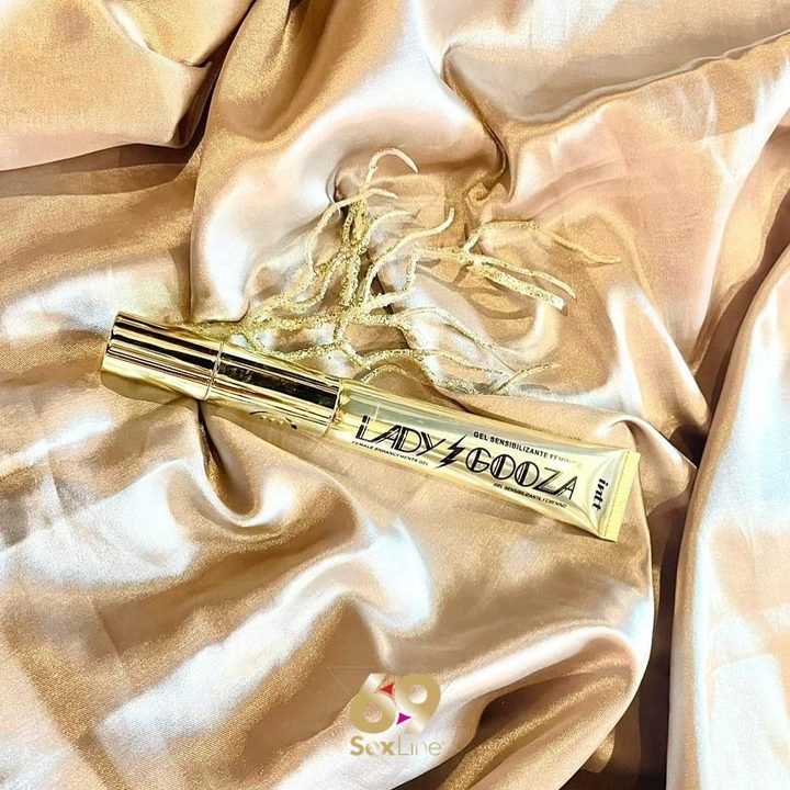 Vibrador dourado sobre tecido de cetim