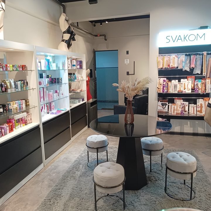 Interior de uma loja 69 Sexline com vitrines iluminadas e poltronas